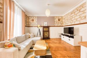 a living room with a couch and a table at Le Saint Mandé - Aux Portes de Paris & Vincennes in Saint-Mandé