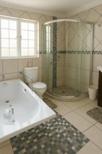 une salle de bain avec une baignoire, des toilettes et une douche dans l'établissement Limonite GuestHouse, à Pretoria