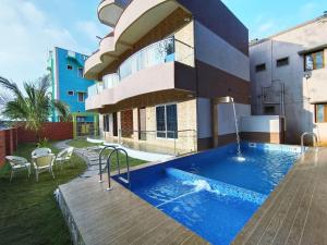 a house with a swimming pool next to a building at Prajay Inn in Yelagiri
