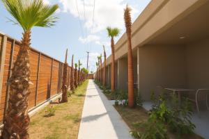 a sidewalk lined with palm trees next to a building at Mono Alex Afitos in Afitos