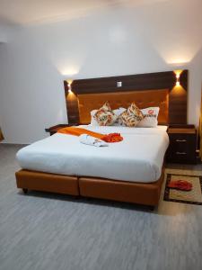 une chambre avec un grand lit avec une tête de lit en bois dans l'établissement Moonshine walkers furnished apartments, à Naivasha