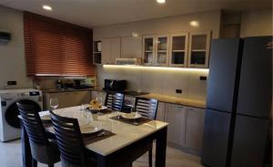 een keuken met een tafel met stoelen en een koelkast bij Palm Spring 301 in Patong Beach