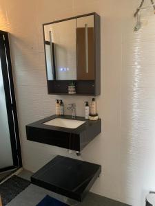 a bathroom with a sink and a mirror at Appartement aux Mamelles in Dakar