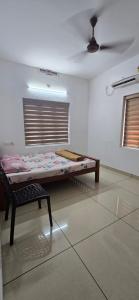 ein Zimmer mit einem Bett und einem Stuhl darin in der Unterkunft 2 bhk apartment near Aster medcity Kochi in Ernakulam