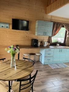 a kitchen with a table with a vase of flowers on it at Brzozowe Zacisze in Narol