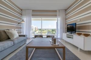 a living room with a couch and a tv at Laguna - Vilamoura in Vilamoura