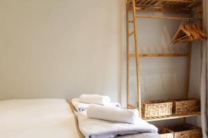 einen Haufen Handtücher auf einem Bett in einem Zimmer in der Unterkunft Spacious 3-Bed Bungalow with Parking in Pensby by Rework Accommodation in Birkenhead