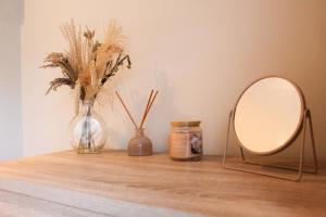 ein Tisch mit Spiegel und Vasen in der Unterkunft Spacious 3-Bed Bungalow with Parking in Pensby by Rework Accommodation in Birkenhead