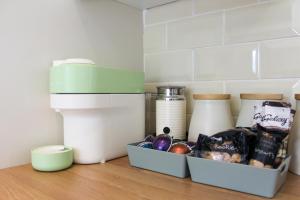 Eine Küchenarbeitsplatte mit einem Behälter mit Lebensmitteln und einem Mixer in der Unterkunft Spacious 3-Bed Bungalow with Parking in Pensby by Rework Accommodation in Birkenhead