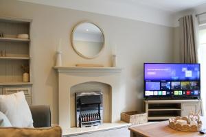 ein Wohnzimmer mit einem TV und einem Kamin in der Unterkunft Spacious 3-Bed Bungalow with Parking in Pensby by Rework Accommodation in Birkenhead + 42 Fotos