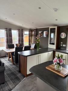 a kitchen with a counter with flowers on it at Hepburns Lodge 19 in Strachan