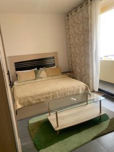 a bedroom with a king sized bed with a coffee table at Appartement aux Mamelles in Dakar