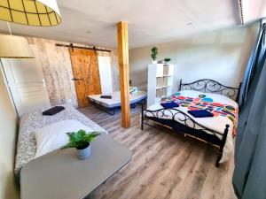 a room with two beds and a table in it at Spacieux de 150 m idéal familles et groupes in Elbeuf
