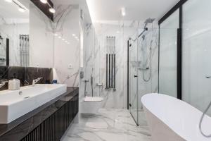 a bathroom with a sink and a toilet and a shower at LUX - Bath with a Baltic View Rewal - SPA Access in Rewal +23 photos