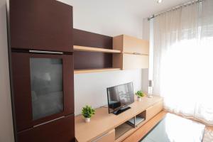 a living room with a television on a wooden table at Armilla Apartament in Armilla +14 photos