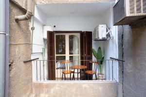 a balcony with three chairs and a table on a window at The Twin Bliss in Cairo