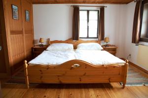 a bedroom with a wooden bed with two pillows at Appartements Grafhube in Verditz