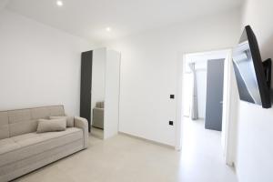 a white living room with a couch and a tv at Mono Alex Afitos in Afitos +12 photos