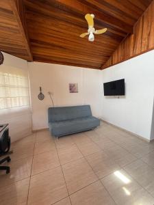 a living room with a blue couch and a ceiling fan at Meu Refúgio Praia Seca in Araruama