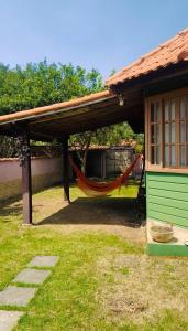 a house with a hammock under a roof at Meu Refúgio Praia Seca in Araruama