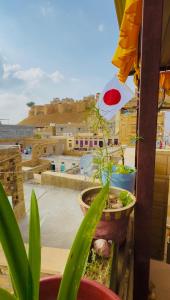 a potted plant on a balcony with a view of a city at Ok-An Homestay in Jaisalmer