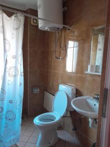 une salle de bain avec des toilettes bleues et un lavabo dans l'établissement Second Sweet Home, à Pristina