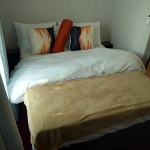 a bed in a room with a pillow and avertisement at Chibu Backpackers Accommodation in Katima Mulilo