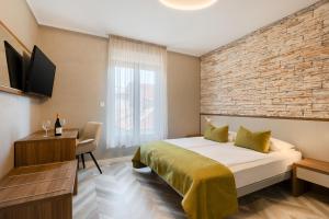 a hotel room with a bed and a brick wall at Pula City Center Accommodation - Breakfast included in Pula