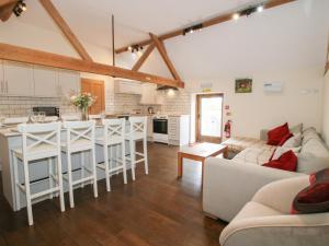 a kitchen and living room with a couch and a table at Millstone Cottages - Breidden View in Shrewsbury