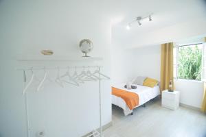 a white bedroom with a bed and a window at Casa Calma III in Tacoronte