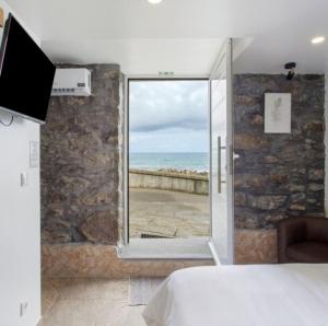 a bedroom with a bed and a view of the ocean at Casa dos avós in São Vicente