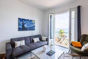 a living room with a couch and a table at Appartement Prestige sur la Promenade des Anglais in Nice