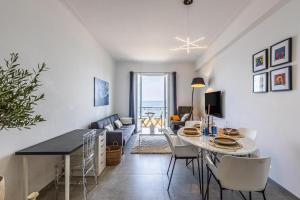 a dining room and living room with a table and chairs at Appartement Prestige sur la Promenade des Anglais in Nice