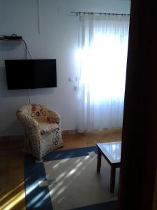 a living room with a chair and a tv at Villa Sol in Vinišće
