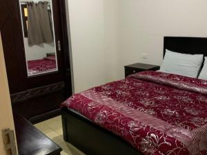 a bedroom with a bed with a red comforter and a mirror at One Bedroom Chalet with Side Sea View ,Turtles, Hurghada Concierge D 14 6 in Hurghada