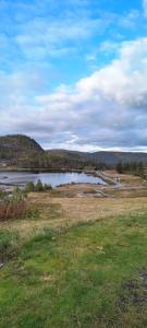 a field with a body of water and a lake at Gautefall ski senter, Bjørnetoppen in Drangedal