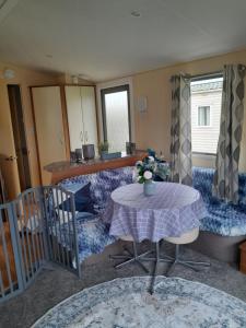 a living room with a table and a kitchen at Static caravan - sleeps 8 in Great Driffield