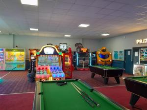 a room with a pool table and arcade games at Static caravan - sleeps 8 in Great Driffield