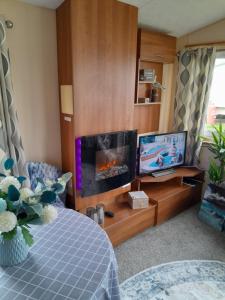 Una sala de estar con chimenea y televisión. en Static caravan - sleeps 8, en Great Driffield 15 fotos más