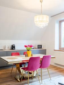 comedor con mesa y sillas rosas en Villa Jarosta Premium, en Zakopane