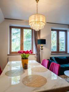 comedor con mesa y sillas rosas en Villa Jarosta Premium, en Zakopane