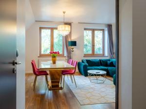 a living room with a blue couch and pink chairs at Villa Jarosta Premium & SPA in Zakopane