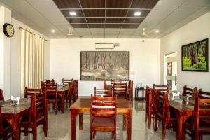 una sala da pranzo con tavoli e sedie in legno di The Ranthambore Samrajya Tiger Seven a Sawai Madhopur
