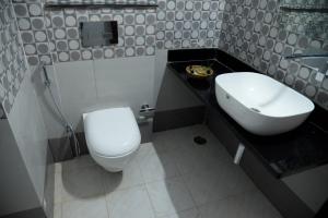 un bagno con un water bianco e un lavandino di The Ranthambore Samrajya Tiger Seven a Sawai Madhopur Altre 7 foto