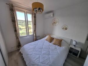 une chambre avec un lit blanc et une fenêtre dans l'établissement MAZET Haut du Golf, à Sainte-Maxime 6 autres photos