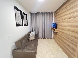 a living room with a couch and a tv at LK Centro 10 in Belo Horizonte