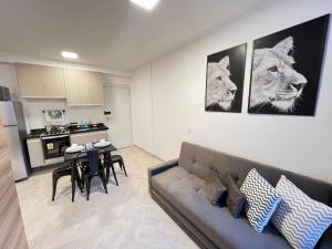 a living room with a couch and a table and a kitchen at LK Centro 10 in Belo Horizonte
