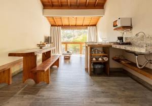 a kitchen with wooden benches and a large window at Villaggio Ronchi in Pedra Azul