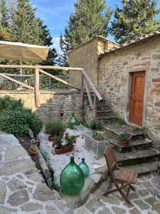 a stone house with a patio with vases and a staircase at Borgo La Valle in Palazzo del Pero +39 photos