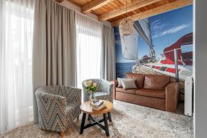 a living room with a couch and chairs and a boat at Rezydencja AMBRE in Łeba